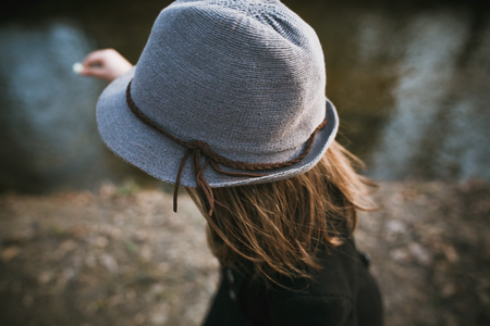 little girl in a black coat and hat posing in autumn park