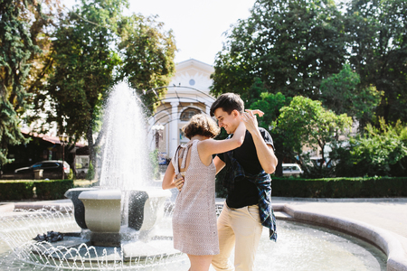 beautiful young couple at the fountain in the parkの写真素材