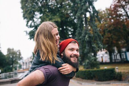 A loving couple walking on the city. A bearded man. Girl with long hair.