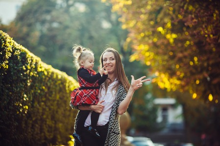 Mother and little daughter playing together in a parkの写真素材