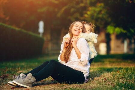 Mother and little daughter playing together in a parkの写真素材