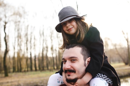 A father carrying his daughter up on his shoulders
