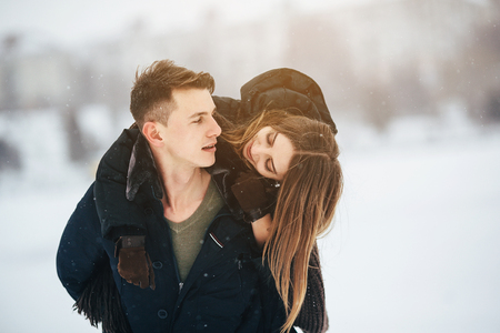 man carries his girlfriend on the back in the park, in winter holidaysの写真素材