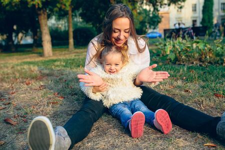 Mother and little daughter playing together in a park