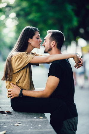 young man gently hugs the girl in the parkの写真素材