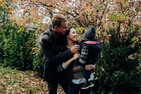 young family and newborn son in autumn parkの写真素材
