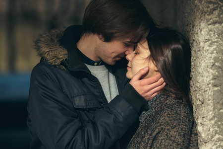 young couple standing together in front of wallの写真素材