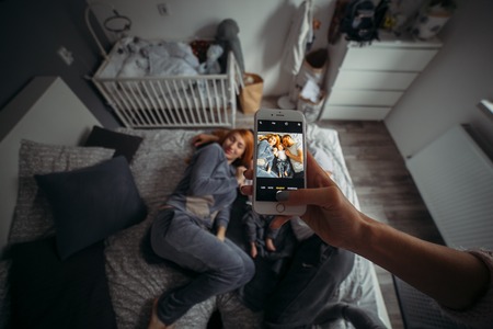 Mother, father and baby on the bedの写真素材