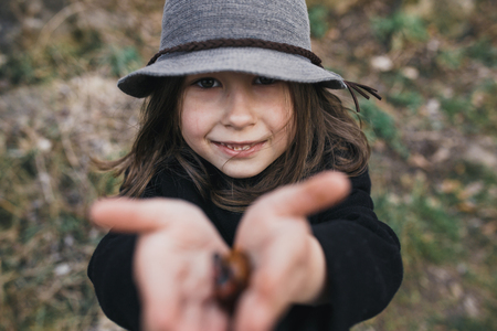 little girl in a black coat and hatの写真素材