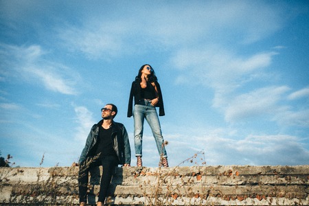 young beautiful couple posing against the skyの写真素材