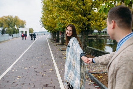 Happy smiling couple on the walk in autumn parkの写真素材