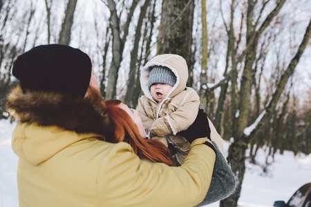 Dad mom and baby in the park in winterの写真素材