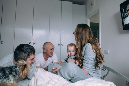 Family playing on bed in the bedroomの写真素材