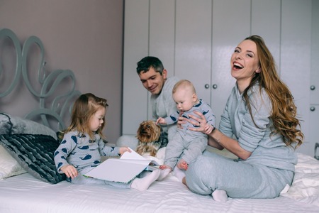 Family playing on bed in the bedroomの写真素材