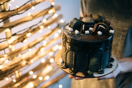 beautiful designer chocolate cake someone holds on hands