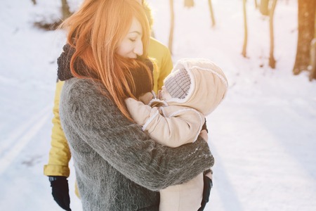 Dad mom and baby in the park in winterの写真素材