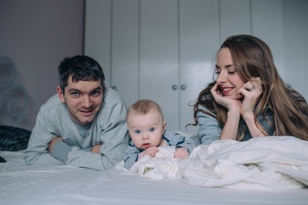 Family playing on bed in the bedroomの写真素材