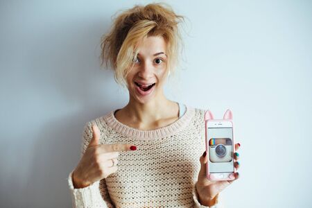 Beautiful girl showing a smart phoneの写真素材