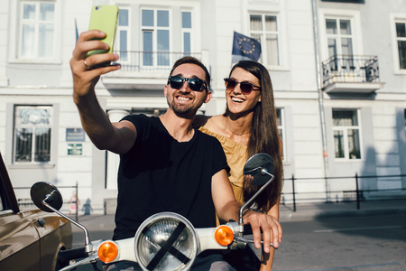 Cute couple make selfie on a scooterの写真素材