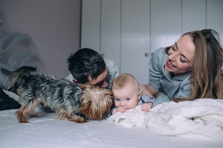 Family playing on bed in the bedroom