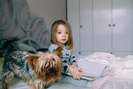 Little girl sitting in bedの写真素材