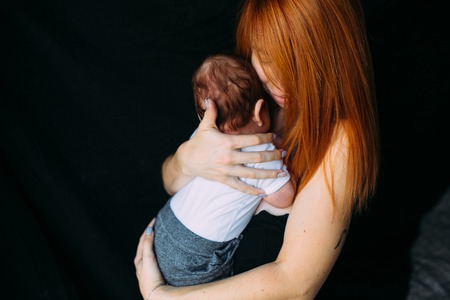 Young mother woman holding her child babyの写真素材