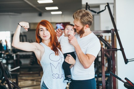 Young family with little boy in the gymの写真素材