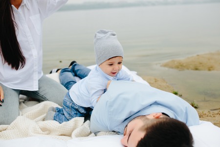 Happy young family relaxing together on the lakeの写真素材