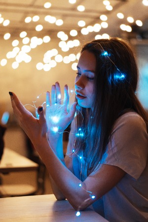 Woman holding glowing christmas garland in handsの写真素材