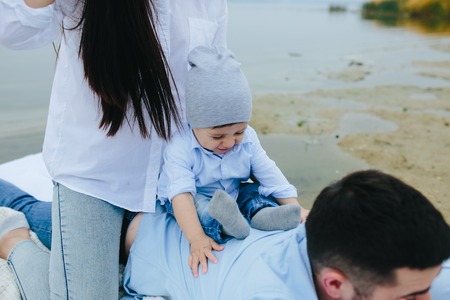 Happy young family relaxing together on the lakeの写真素材