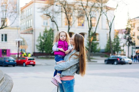Mother holds a small daughter in her armsの写真素材