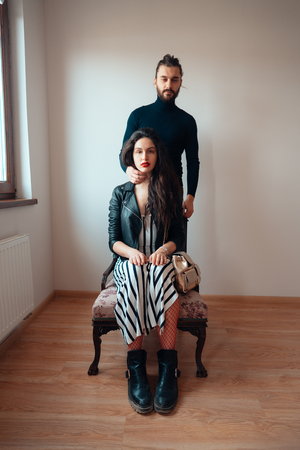 Girl sitting on a chair guy standing behind herの写真素材