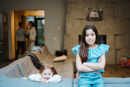 Elder and younger daughter on the big couchの写真素材