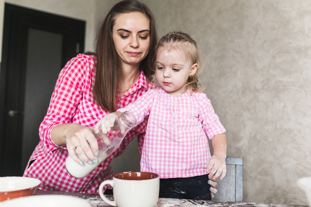Mom and daughter together in the kitchenの写真素材