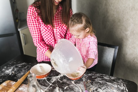 Mom and daughter together in the kitchenの写真素材