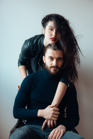 Guy sitting on a chair, girl standing behind himの写真素材