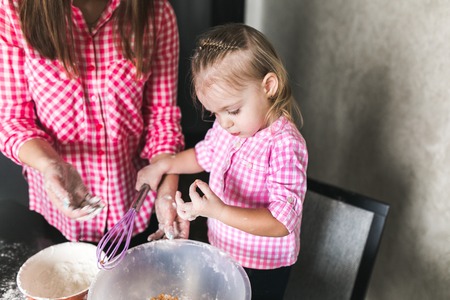 Mom and daughter together in the kitchenの写真素材