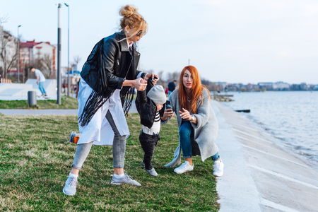 Two women and a little boy on the lakeの写真素材