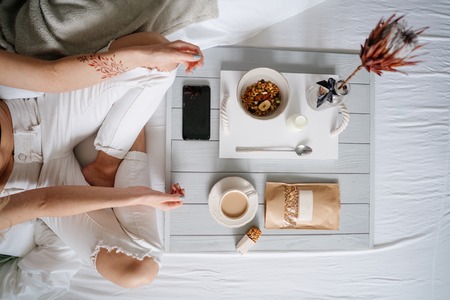 Woman eating cereals in bedの写真素材