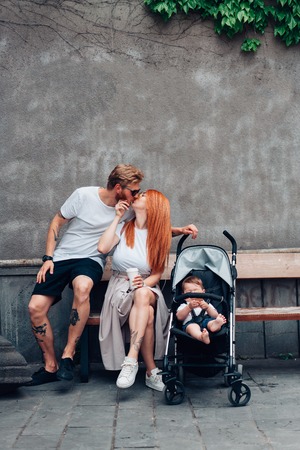 Mom, Dad and little son in a pramの写真素材