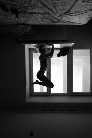woman doing yoga asana on window sillの写真素材