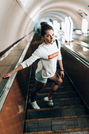 Beautiful young girl on escalatorの写真素材