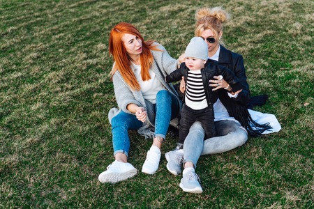 Mom and aunt play with a boy in the Park