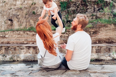 The family sit on the river bank