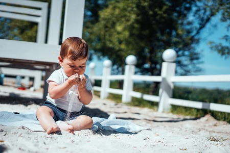 Little baby boy sitting on the sandの写真素材
