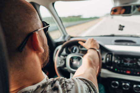 The man in the car traveling on the roadの写真素材