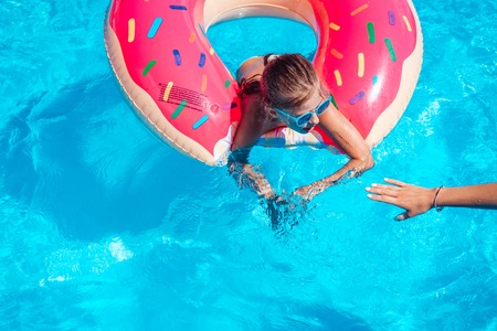 Girl on inflatable ring in swimming poolの写真素材
