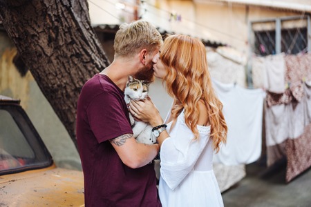 beautiful couple and cat posing outdoorsの写真素材