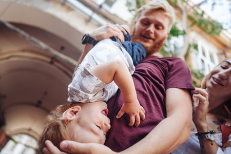 Happy parents playing with little son outdoorの写真素材