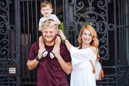 Happy parents playing with little son outdoor